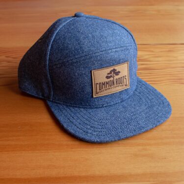 Blue wool hat with brown leather Common Roots patch on front