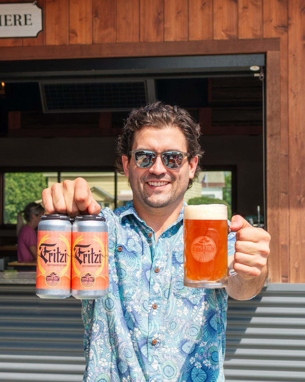 Man Holding mug of Fritzi and a 4pack of fritzi