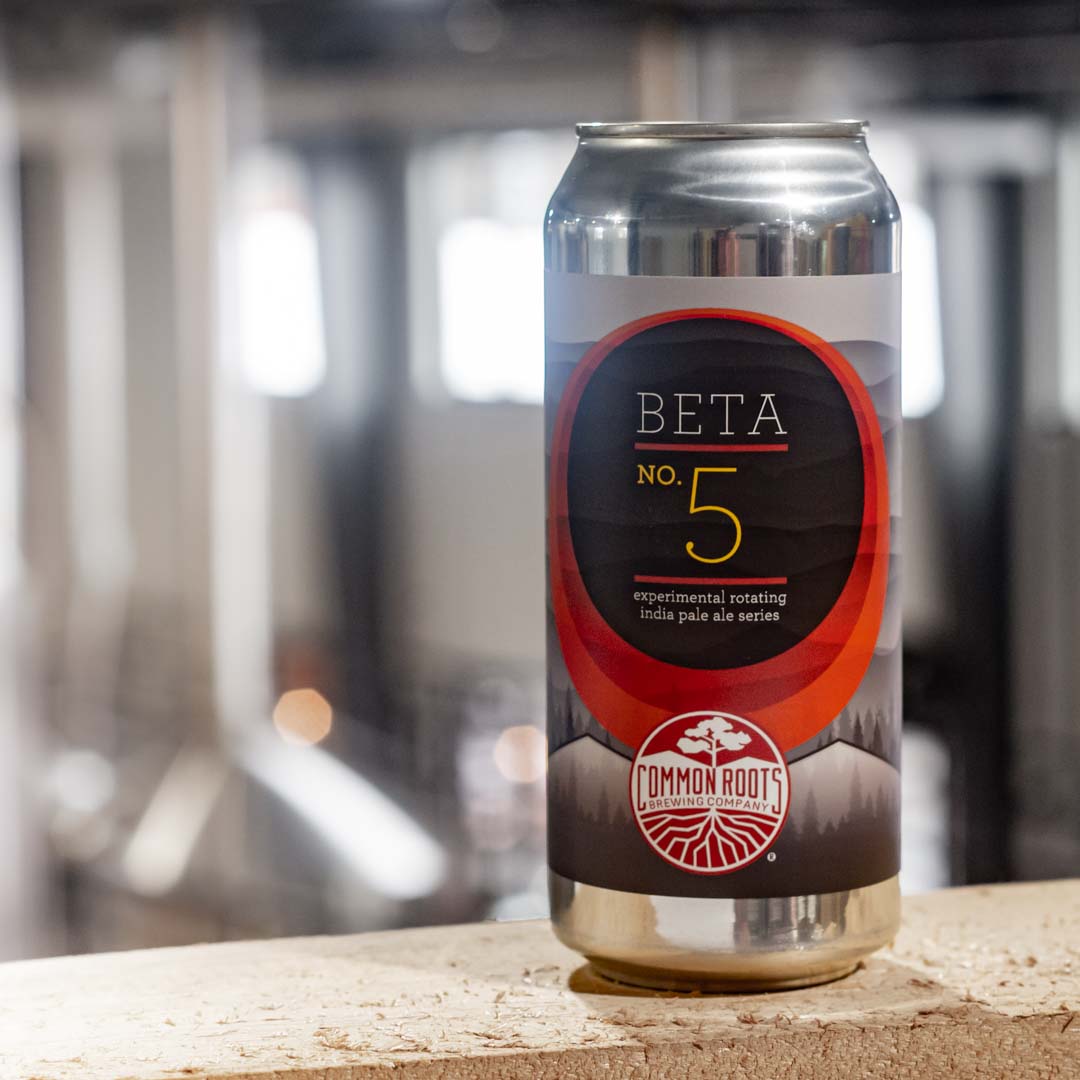 Beta can of beer with stainless brewing vessels in the background