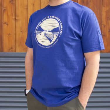 Navy blue tee shirt with a cream colored canoe and lake scene on the front
