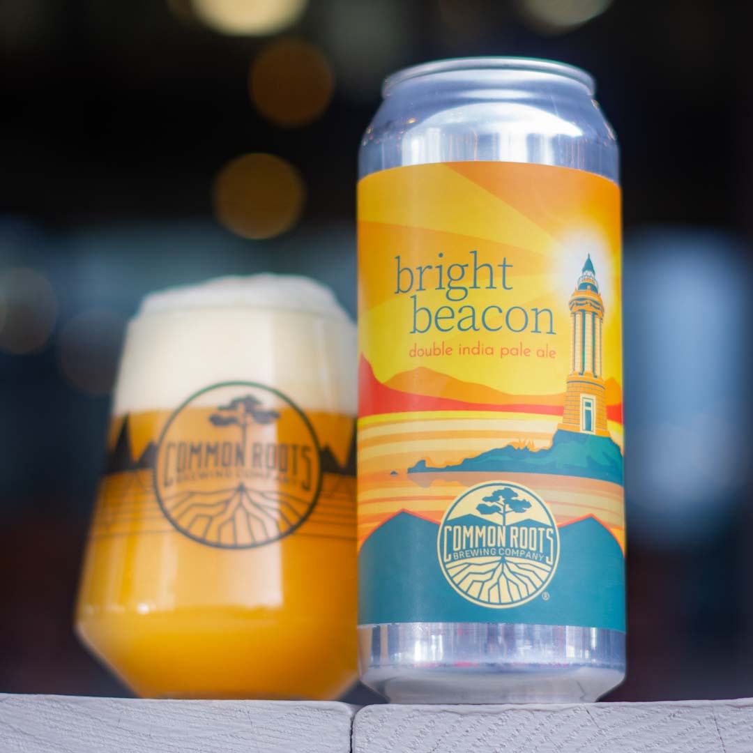 Can of Bright Beacon next to a glass of beer