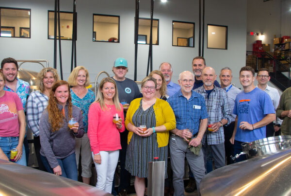 Group of people holding beers and smiling