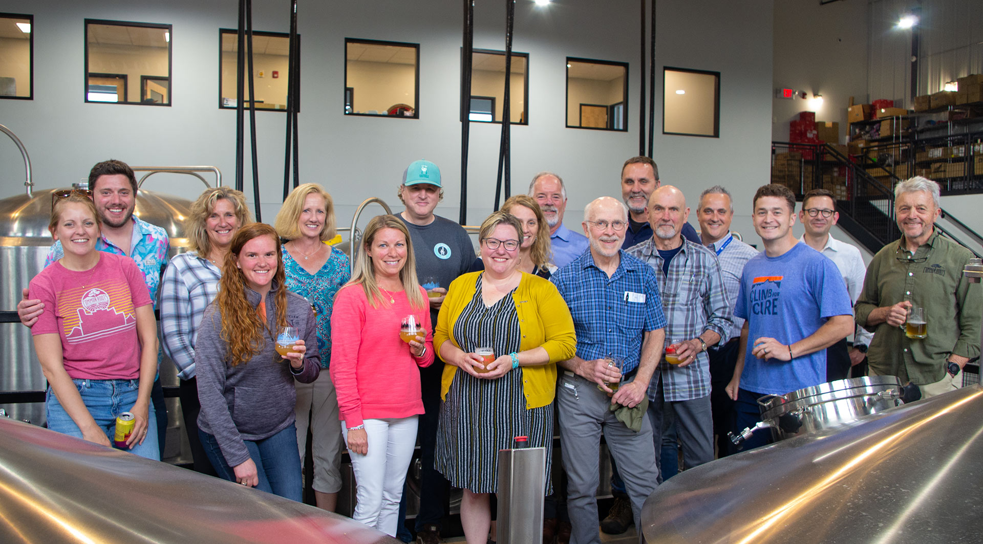 Group of people holding beers and smiling