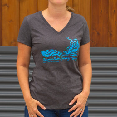 Woman wearing a dark gray tee with a blue wave graphic on it.