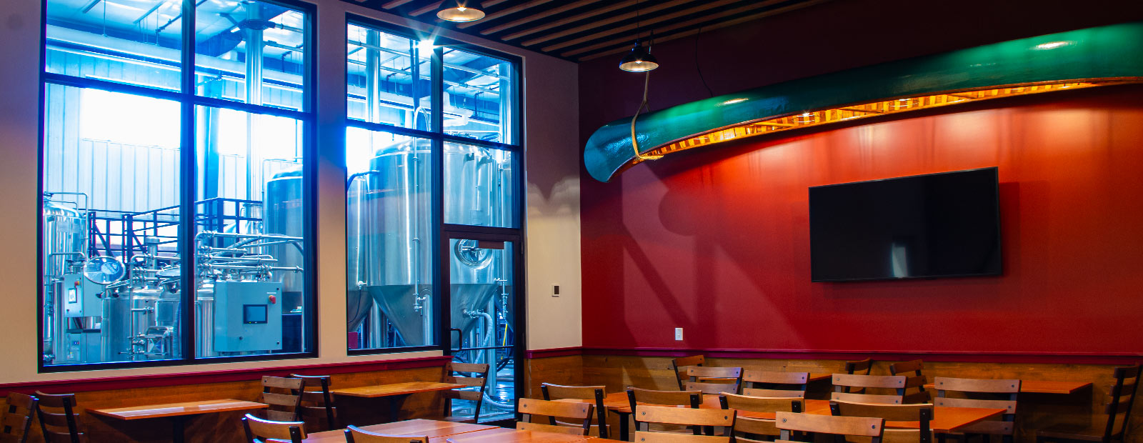 Room with red accent wall and green canoe hanging from the ceiling