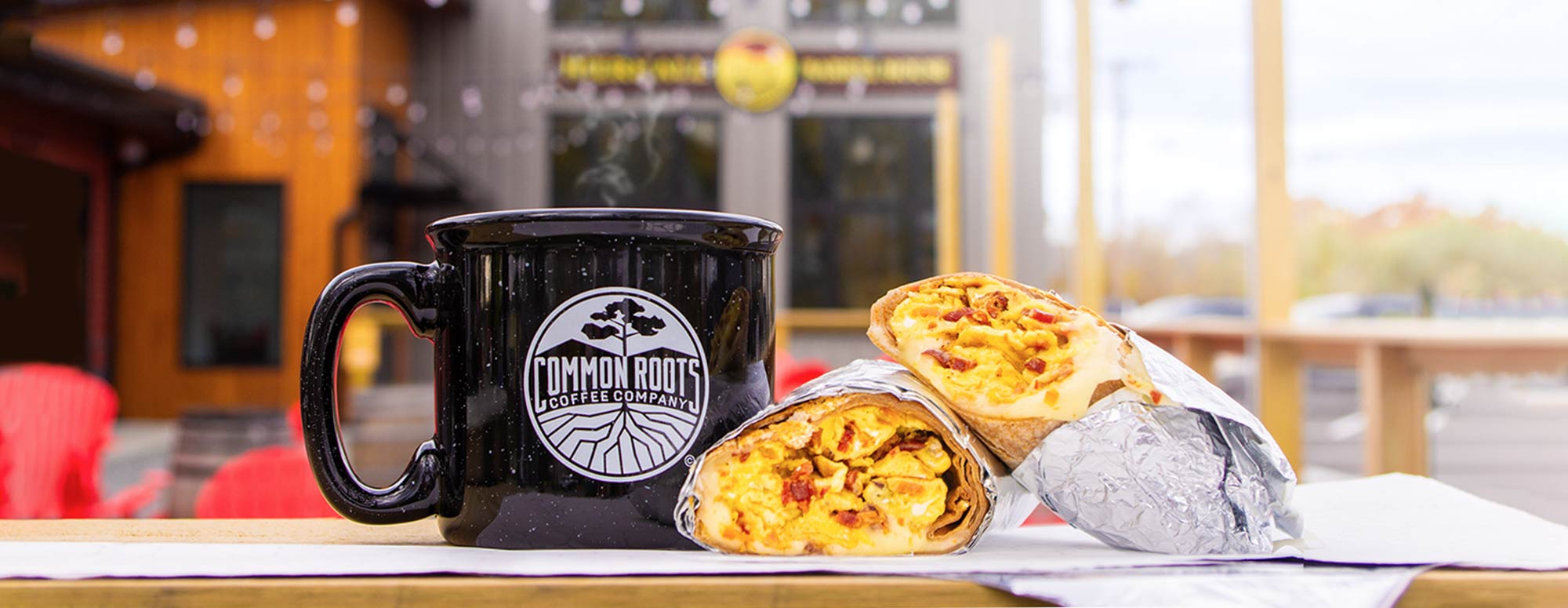 Steaming mug of coffee next to a breakfast burrito