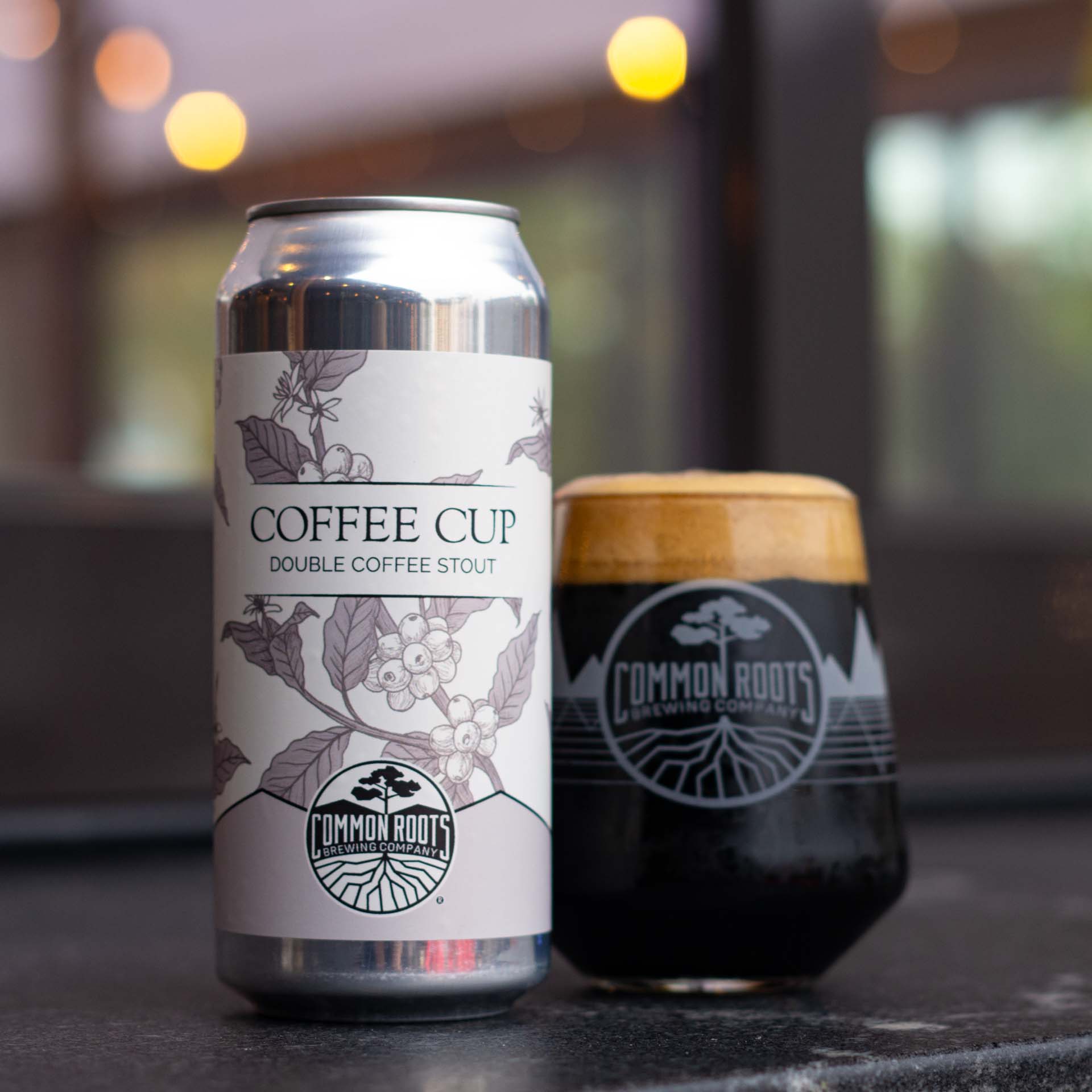 Can of Coffee Cup Stout next to a glass of dark beer