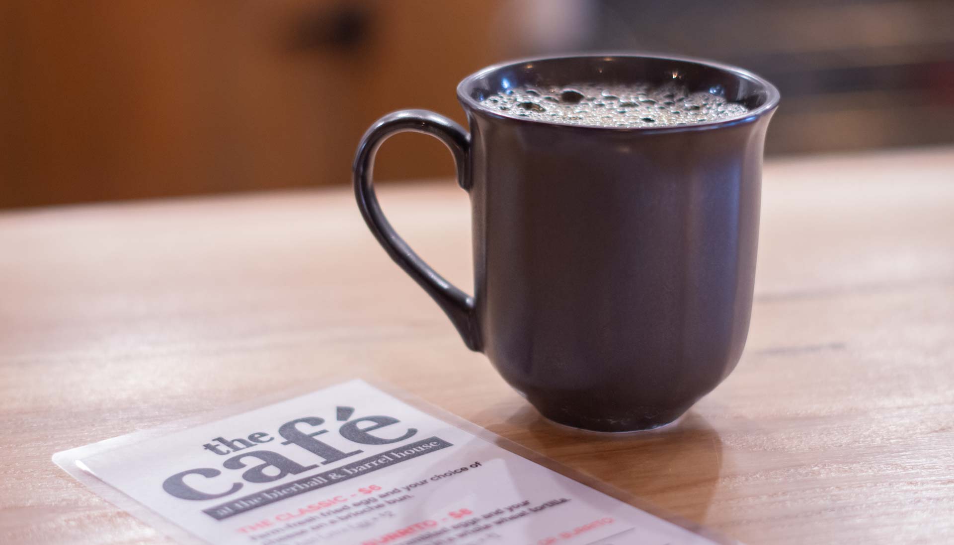 Cup of coffee next to a cafe menu