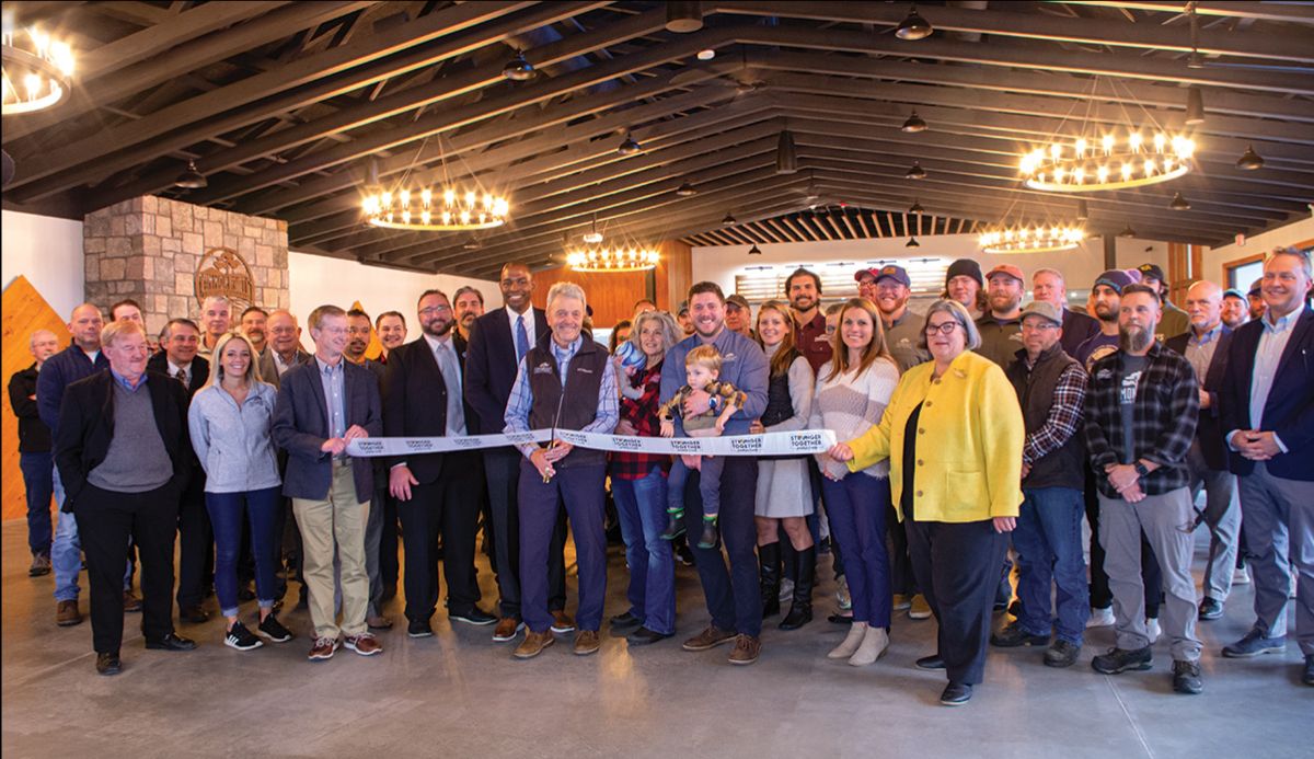 Group of people watching a ribbon cutting