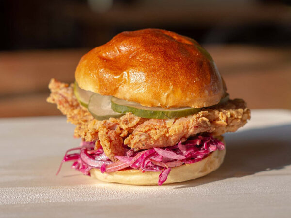 Crispy chicken on a fluffy bun with fresh slaw and pickles.