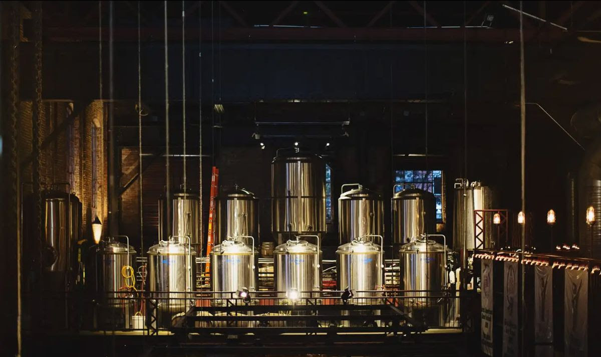 Stainless steel brewing tanks with dark moody lighting