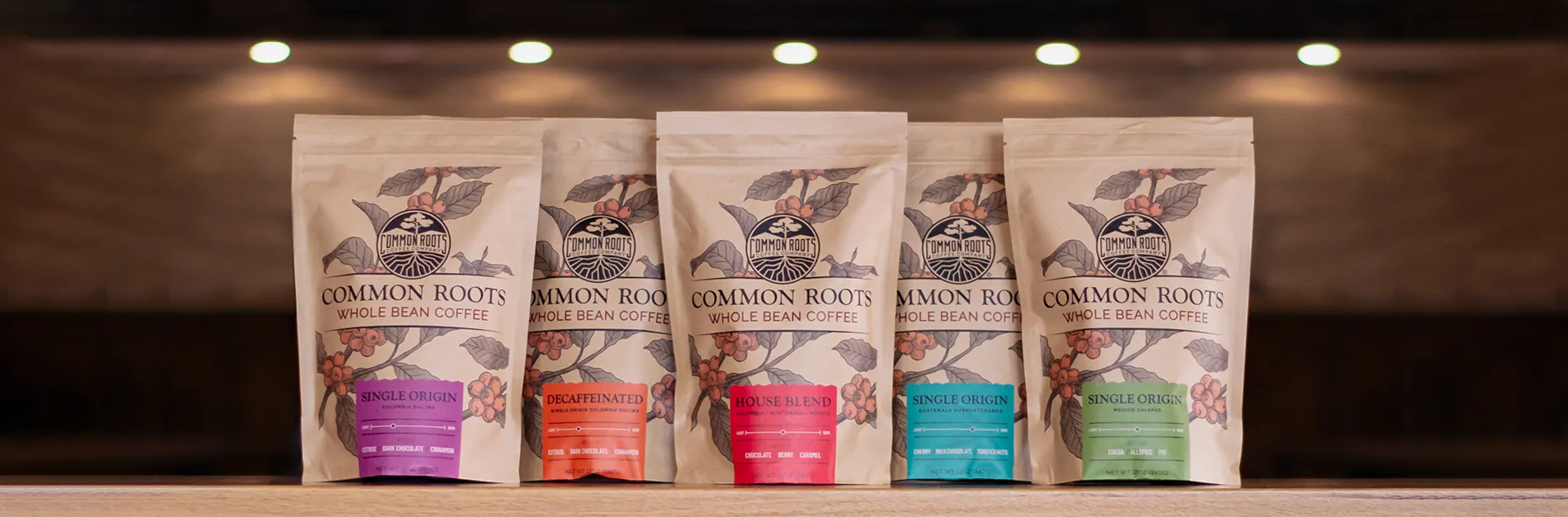 Five colorful bags of packaged coffee on a wooden table