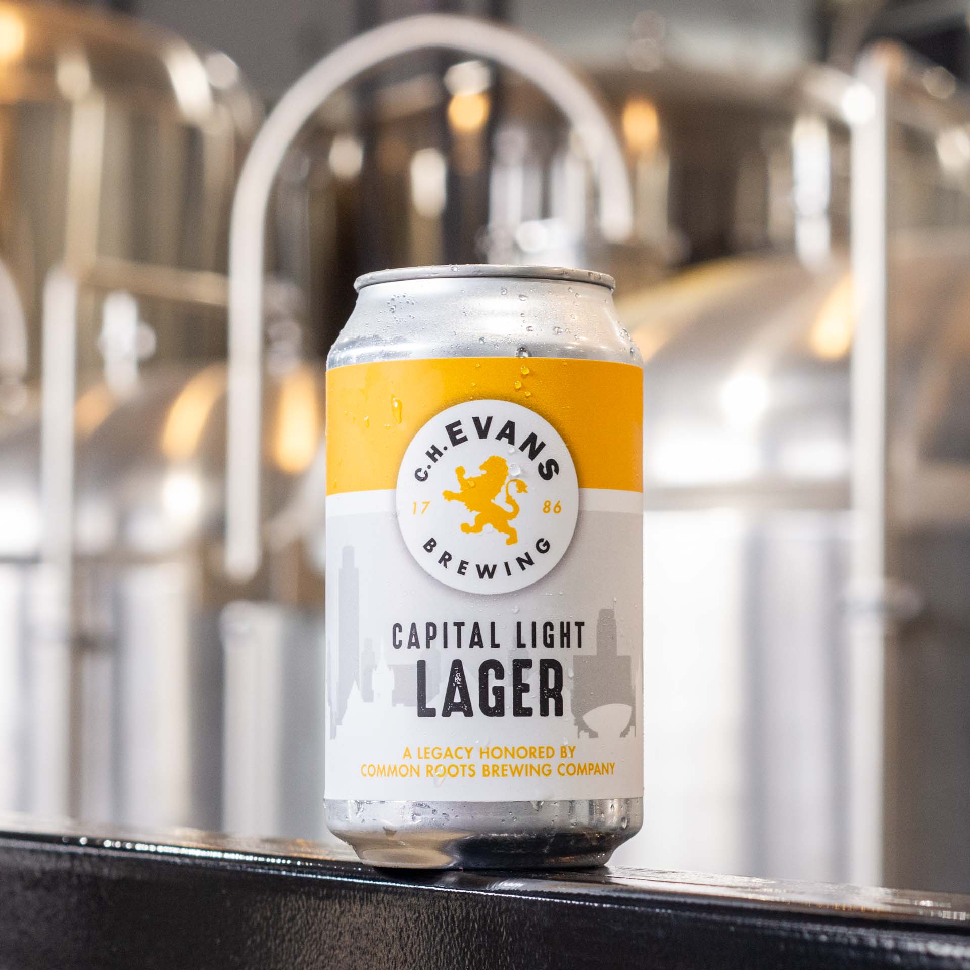 Can of Capital Light lager with shiny brewing vessels in the background