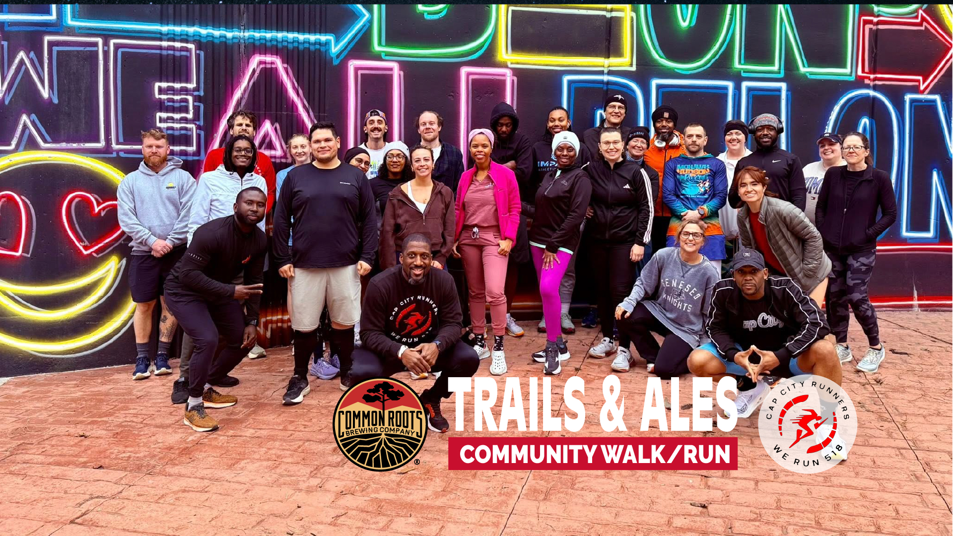 Runners Posing infront of a mural in Albany