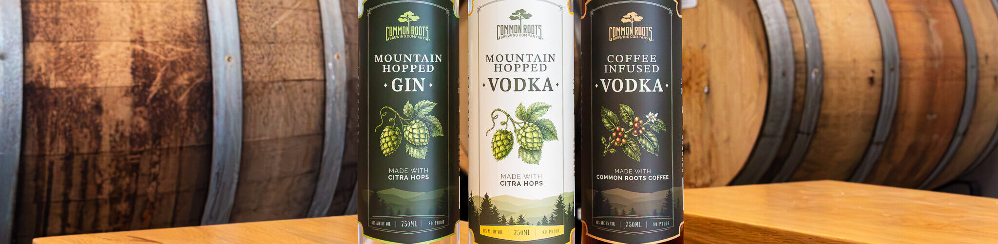 Common Roots Spirits Bottles lined up on a bench